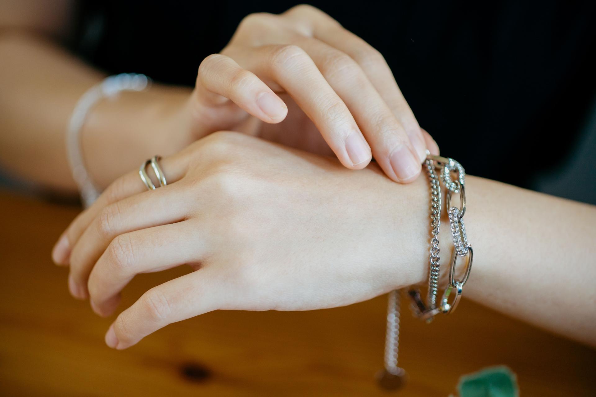 An Asian women's hand showing luxury accessories such as silver ring and bracelet