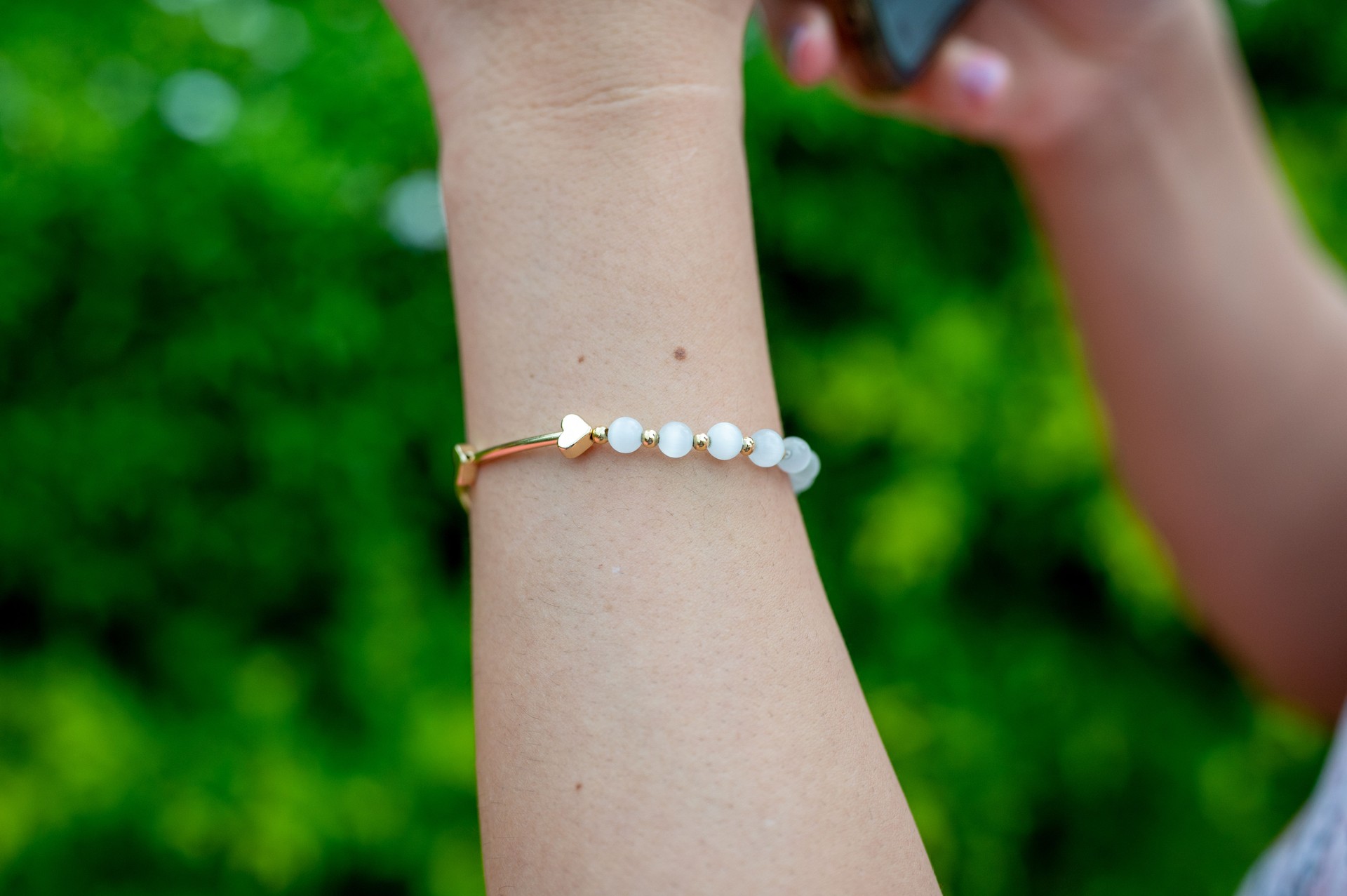 Close-up of women's hand showing luxury accessories such as gemstone gold bracelet